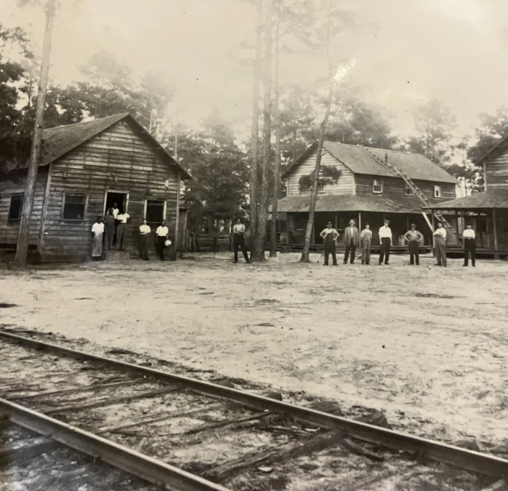 African American millworkers lived in the “Quarters,” just below the Waccamaw Lumber Co.’s mill in Bolton. Italian, Russian, and other immigrant laborers may also have stayed there. One of the buildings was a boardinghouse “sorta like barracks in the army,” one of the former employees told the students from Kin’ Lin.’ The ladder on the middle building was apparently a fixture: it served as a fire escape. Courtesy, Waccamaw Photographs & Journal, Rubenstein Library, Duke University
