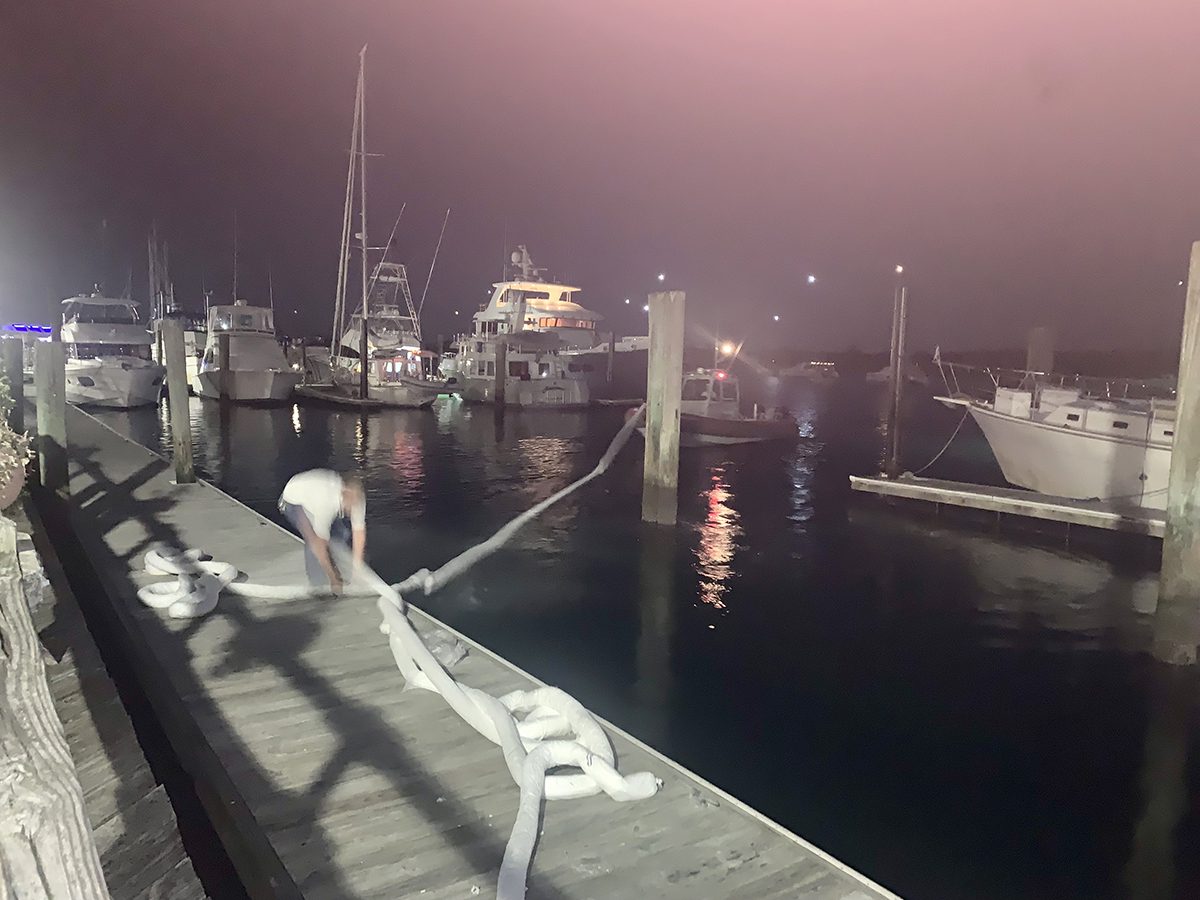 A team from Atlantic Coast Marine Services places booms in the water around the diesel fuel spill at the Beaufort Docks Saturday night. Photo: Mark Hibbs