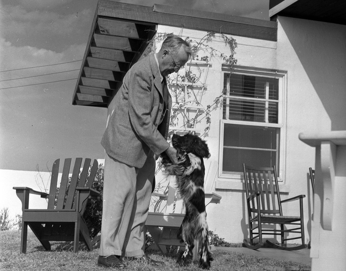 Frank Stick plays with his dog outside a Flat Top cottage in 1950. Photo: Charles Brantley 'Aycock' Brown and courtesy of the Maud Hayes Stick Collection at the Outer Banks History Center/North Carolina State Archives.