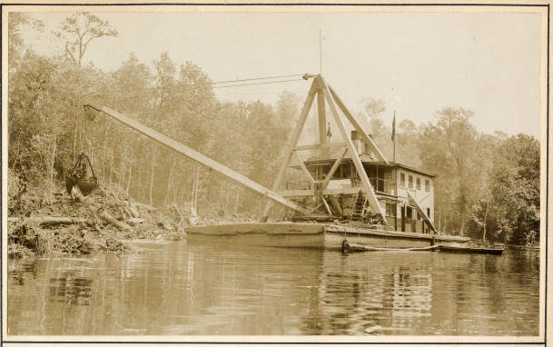 The Corps’ derrick barge No. 14 on a section of the Scuppernong River near Creswell, N.C., May 1931. According to the U.S. Army’s Report of the Chief of Engineers for 1931, the dredge’s crew spent 3 months that year removing snags from the upper part of the Scuppernong and trimming and straightening the river’s bank. The Scuppernong is a roughly 30-mile-long blackwater river that rises in eastern Washington County, crosses into Tyrrell County and flows into Bull Bay, on the south side of the Albemarle Sound.  Prior to the 1870s, the head of navigation for steamers on the Scuppernong was a site called Spruills Bridge, 23 miles from the river’s mouth. Over the next half century, the Corps’ dredges had extended navigation a little more than 2 miles farther upriver, into a narrow, winding section of the river in Washington County, near the community of Cherry.  Corps dredges had also doubled the depth of the river’s bar and done a good deal of channel dredging, including excavating a 10-foot channel from the river’s bar to the town of Columbia. Source: Office of History, HQ, U.S. Army Corps of Engineers

