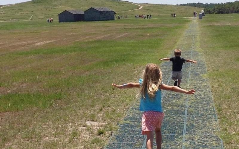 Children run along the flight line at Wright Brothers National Memorial. Photo: NPS