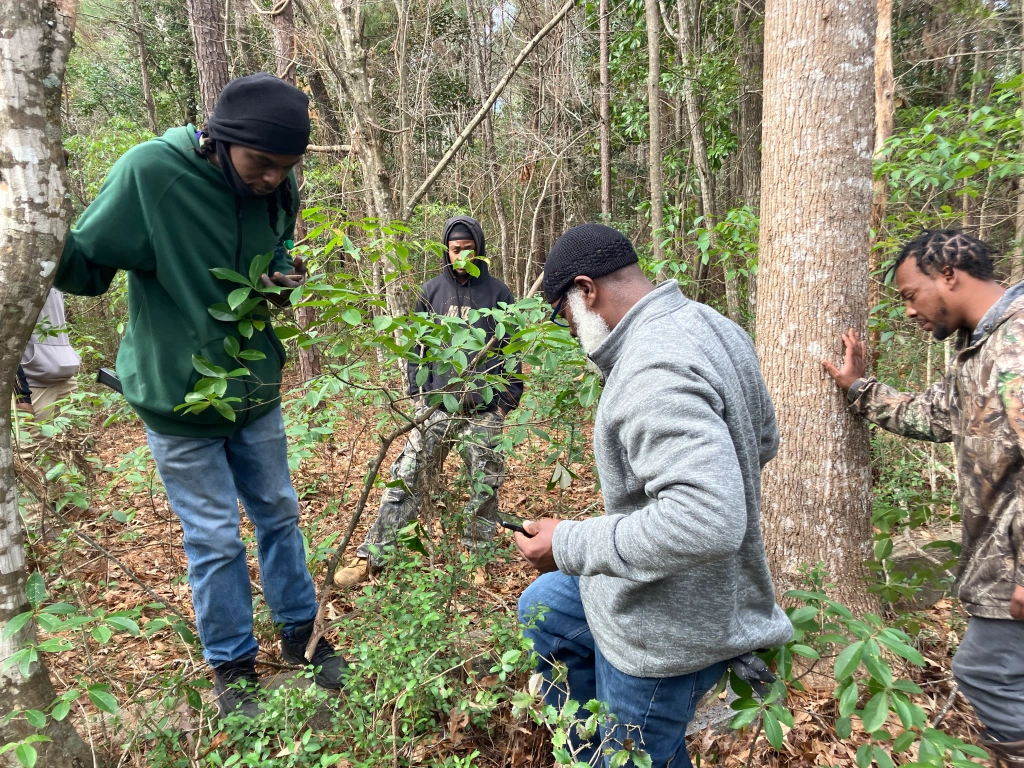 (Left to right) Wesley Newsome, Joseph Smith, Vinnie Joyner, and BJ Herring at an old cemetery just up the road from Pinch Gut Creek. Photo by David Cecelski
