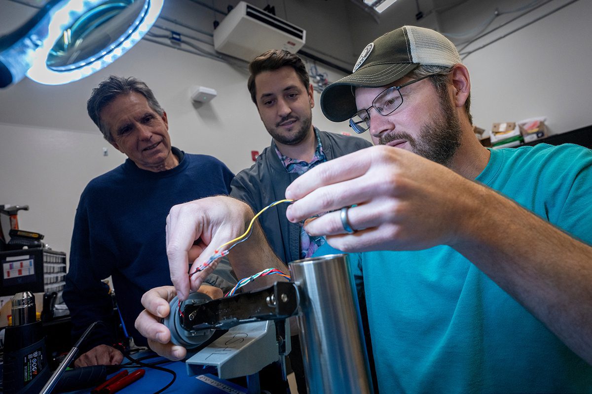 Coastal Engineering student Dayton Thompson, right, assembles sensors as part of a federal grant awarded to Coastal Engineering professor Ryan Mieras, center. Sean Griffin, left, of Proteus Technologies works with Mieras to help create the sensors. Photo: Jeff Janowski/UNCW