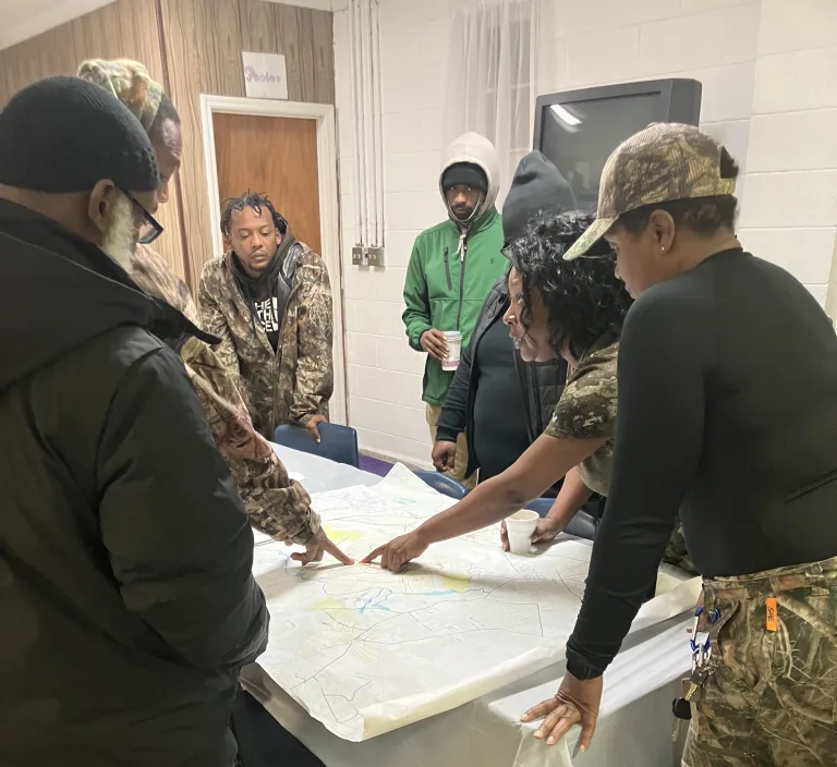 (Left to right) Vinnie Joyner, Nick Smith, BJ Herring, Antwan Evans, Melissa Evans, Marion Evans, and April O’Neal at Friendship Holiness Church. Marion started the day pointing out some of the sites that she was hoping to find on a 1913 survey map of Piney Grove.  Photo by David Cecelski

