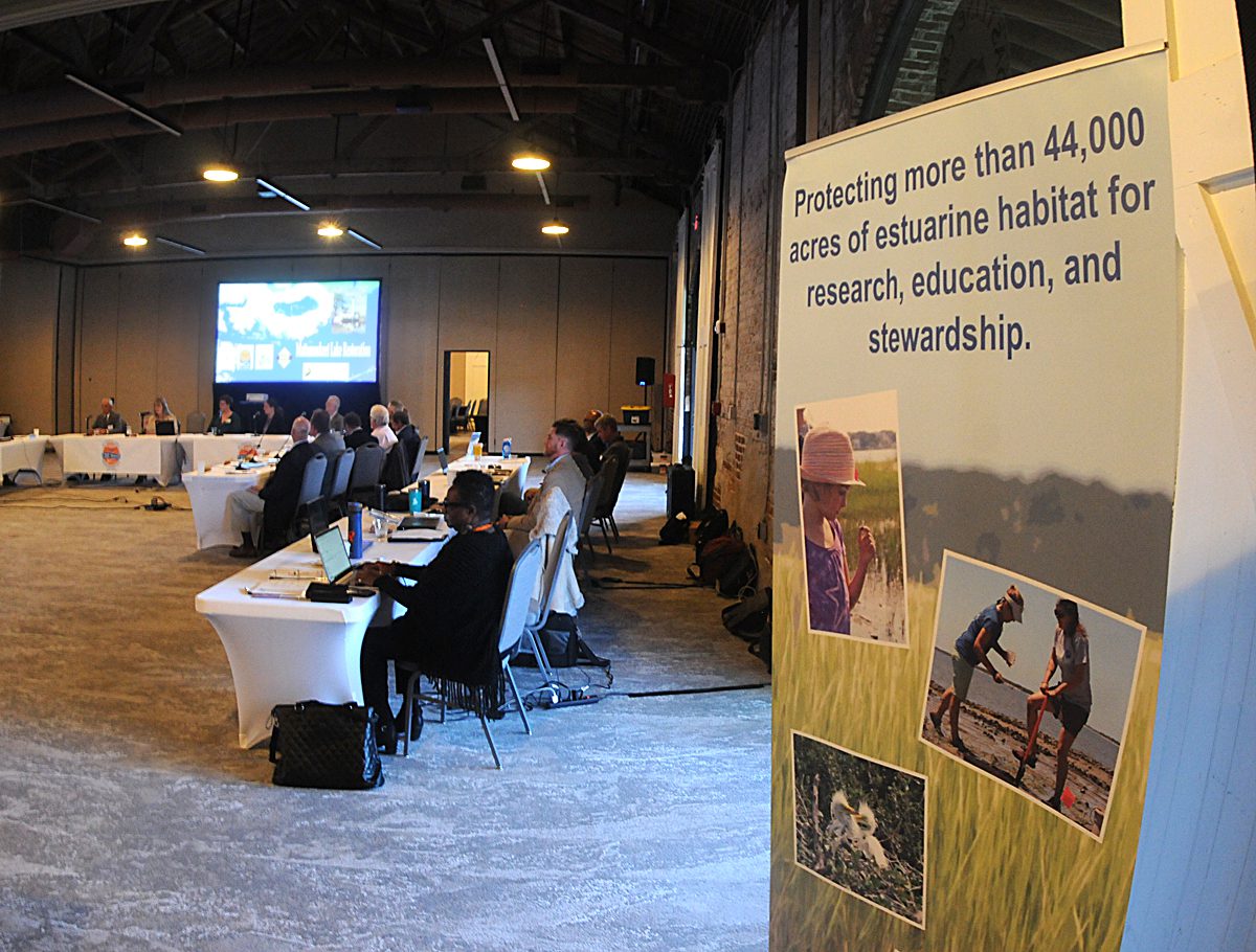 A banner on display Thursday at the state Coastal Resources Commission meeting in Wilmington touts one of the accomplishments of the Coastal Area Management Act. Photo by Mark Courtney