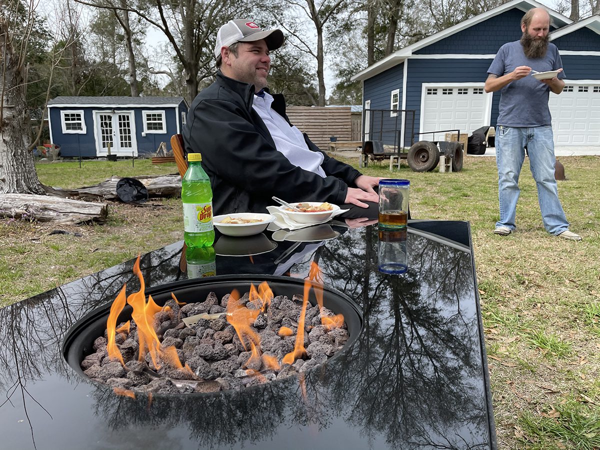 Trey Herring, left, and Steve Jolley savor the fish stew they cooked according to a method passed down through generations of their families. Photo: Liz Biro