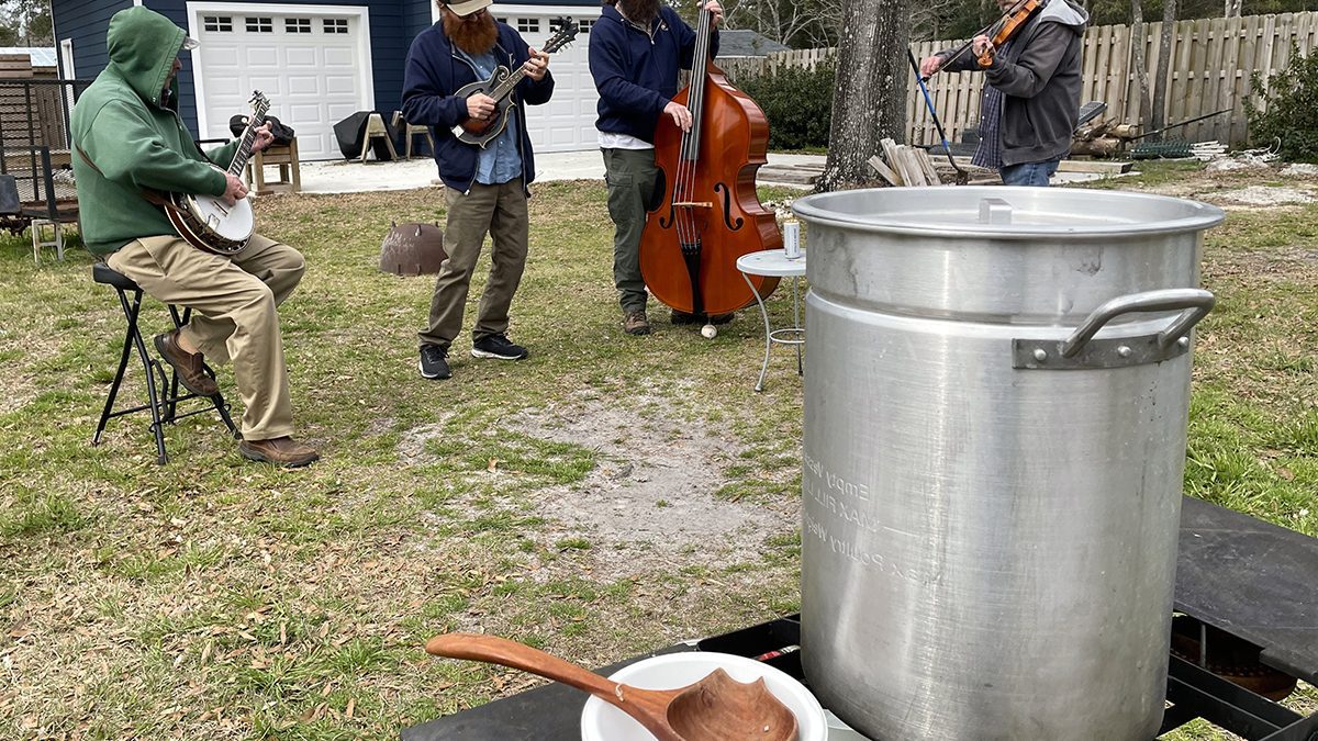 A wooden ladle waits for takers alongside Eastern North Carolina fish stew as Wilmington-based Folkstone String Band plays bluegrass. Photo: Liz Biro