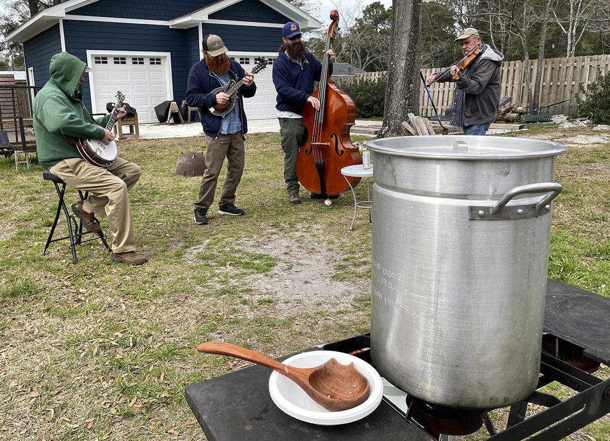 A wooden ladle waits for takers alongside Eastern North Carolina fish stew as Wilmington-based Folkstone String Band plays bluegrass. Photo: Liz Biro