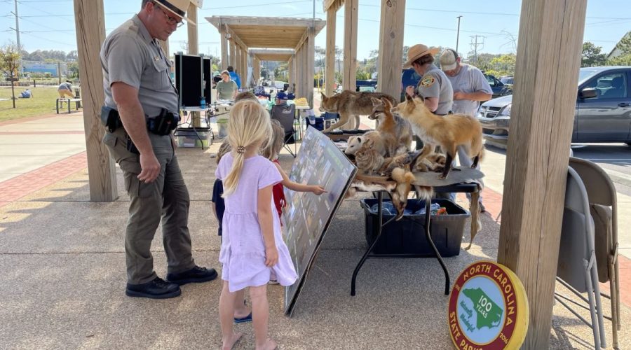 Exhibitors talk to young guests during a Past Earth Fair OBX at Dowdy Park in Nags Head. This year's fair will be at Jockey's Ridge State Park. Photo: N.C. Coastal Federation