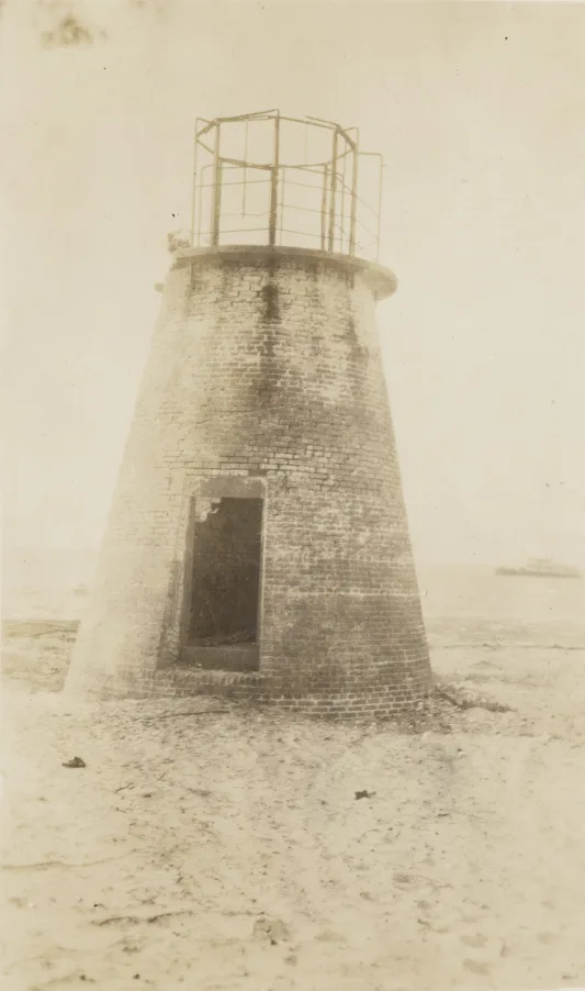 This is a 1917 view of the ruins of the surviving range light on that part of the Cape Fear River– the Price’s Creek Front Range Light, with the USLS tender Palmetto in the distance. Photo source: Records of the U.S. Coast Guard (RG 26), National Archives- College Park (#45694439)