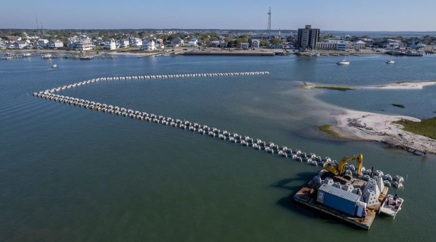 This aerial photo taken in late April shows the rows of wave attenuator devices being placed around the west side of Sugarloaf Island as part of a hybrid project to restore the barrier island. Photo: Dylan Ray