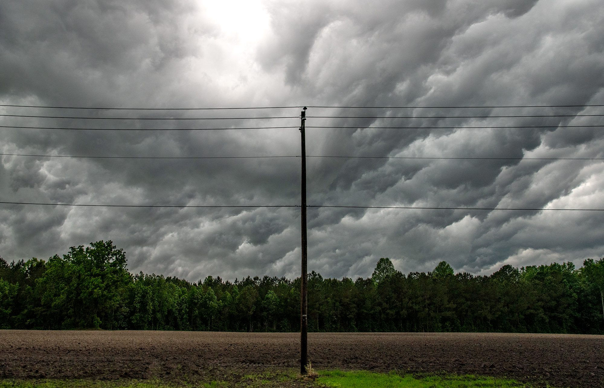 Lines of clouds move over Askin near New Bern and the power lines overhead as part of a weekend weather front. Photo: Dylan Ray