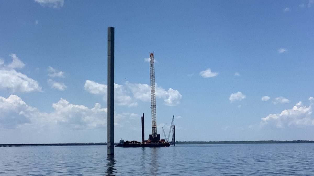 Concrete test piles are shown driven into the riverbed at various depths. Photo: NCDOT