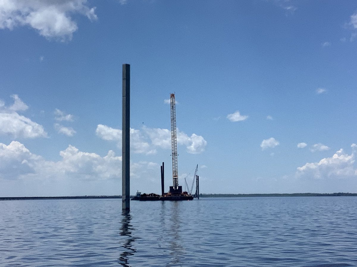 Concrete test piles are shown driven into the riverbed at various depths. Photo: NCDOT