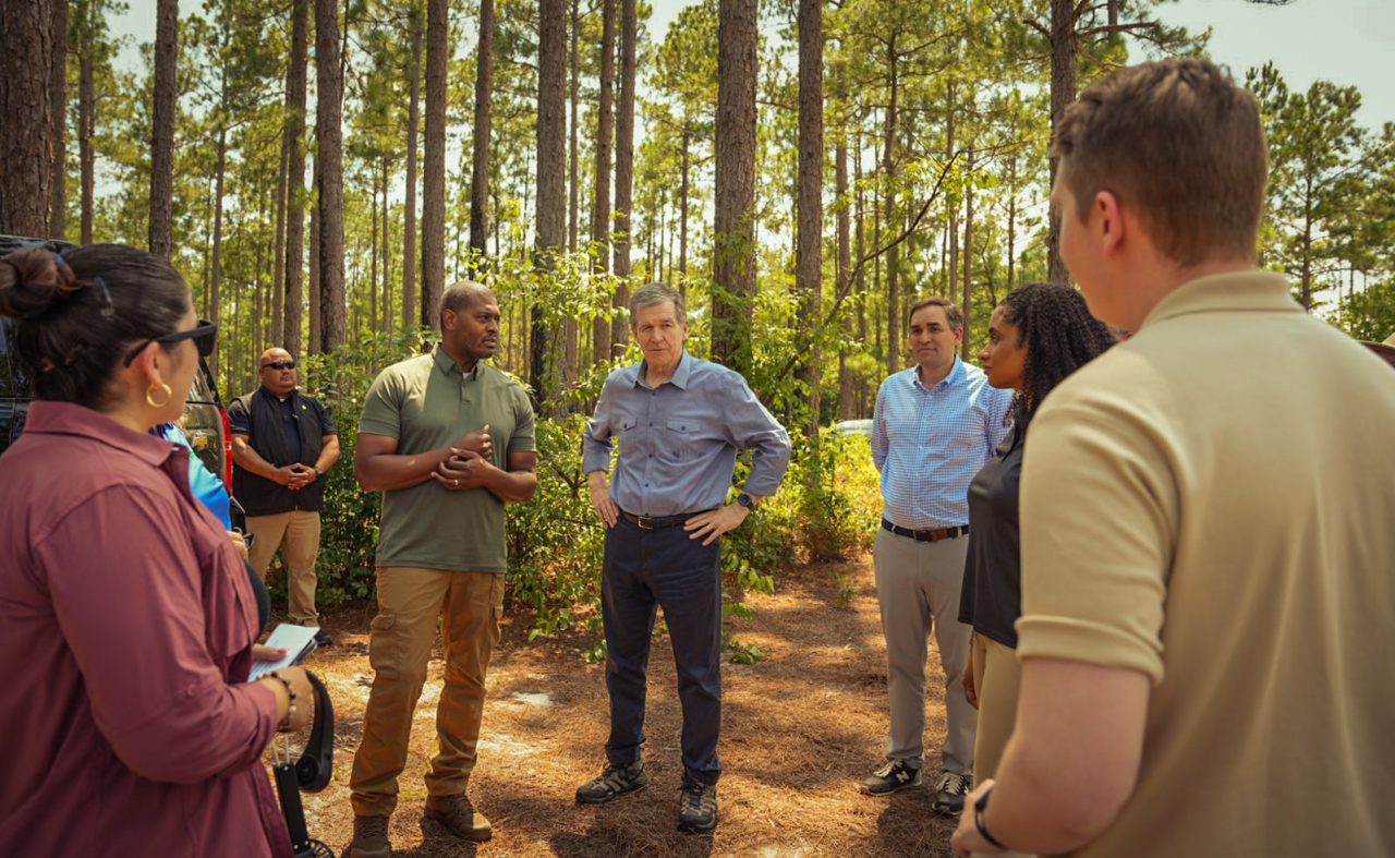 Environmental Protection Agency Administrator Michael Regan, center left, and Gov. Roy Cooper are encircled Tuesday by attendees at a press event in the Green Swamp Preserve. Photo: Courtesy, EPA