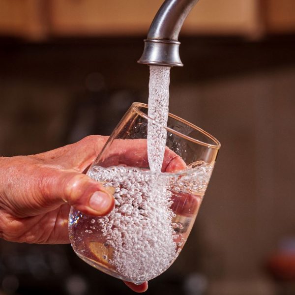 Tap water flows from a faucet into a glass. Photo: EPA, Eric Vance
