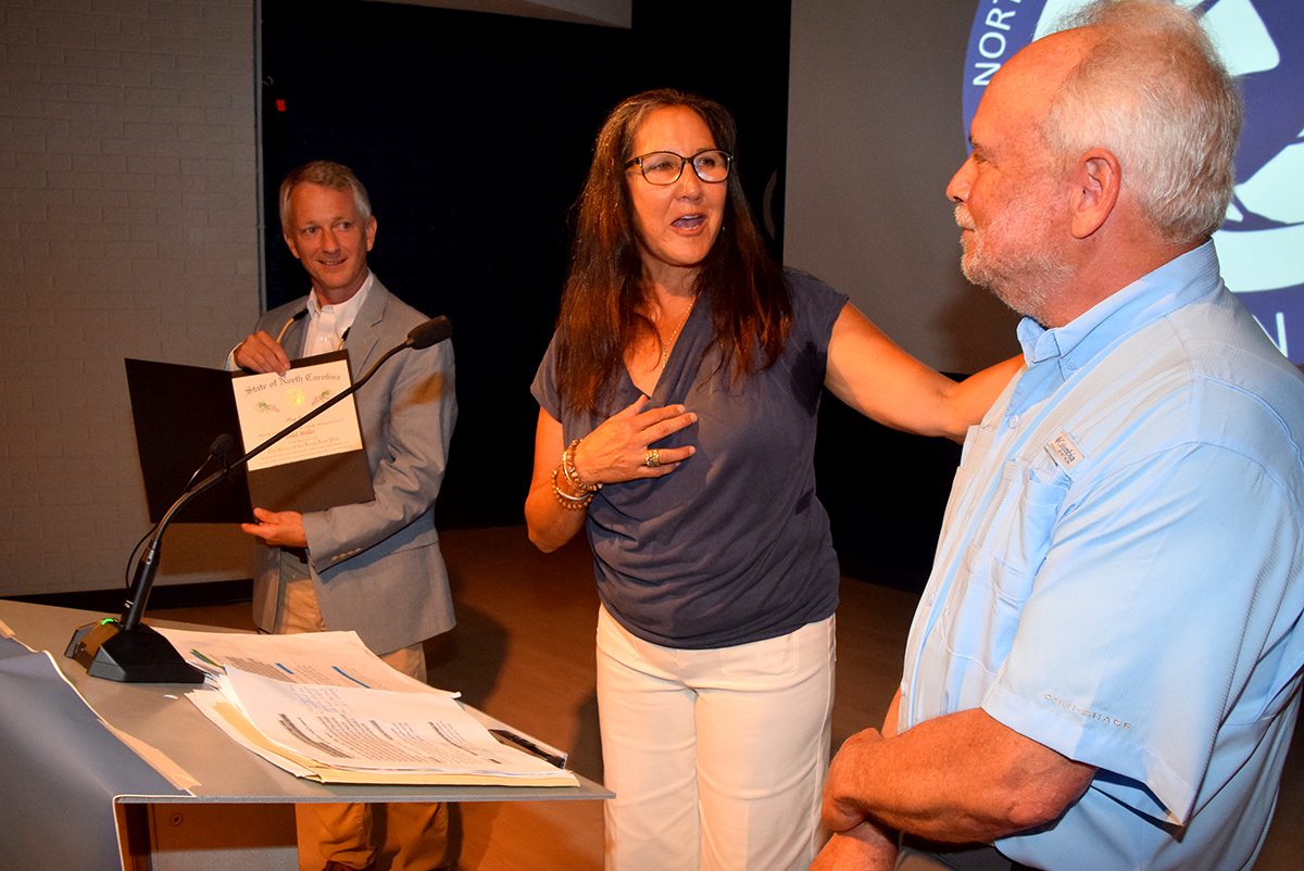 Executive Director Braxton Davis, left, and Board of Directors President April Clark present to founder Todd Miller The Order of the Long  Leaf Pine, the governor's highest honor for service. Photo: Mark Hibbs