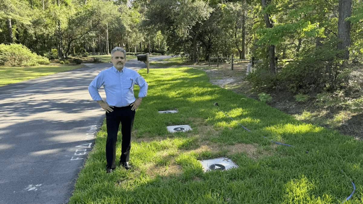 Wilmington resident Steve Schnitzler stands next to the caps for three monitoring wells installed by Chemours to monitor PFAS contamination in his neighborhood's groundwater. In 2023, Schnitzler's drinking water well was tested, and the results showed PFAS levels that exceeded the EPA's drinking water health advisory. Per the consent order requirements, Chemours covered the cost of four reverse osmosis water filtration systems installed in his home. Photo: Will Atwater