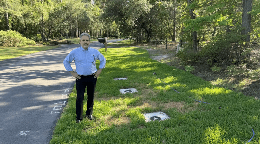 Wilmington resident Steve Schnitzler stands next to the caps for three monitoring wells installed by Chemours to monitor PFAS contamination in his neighborhood's groundwater. In 2023, Schnitzler's drinking water well was tested, and the results showed PFAS levels that exceeded the EPA's drinking water health advisory. Per the consent order requirements, Chemours covered the cost of four reverse osmosis water filtration systems installed in his home. Photo: Will Atwater