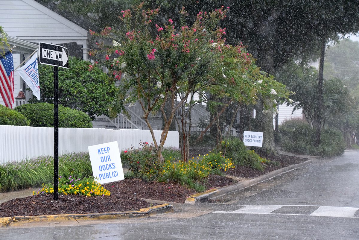 Signs reading "Keep Our Docks Public!" dot a rainy street in Beaufort Monday. Photo: Mark Hibbs