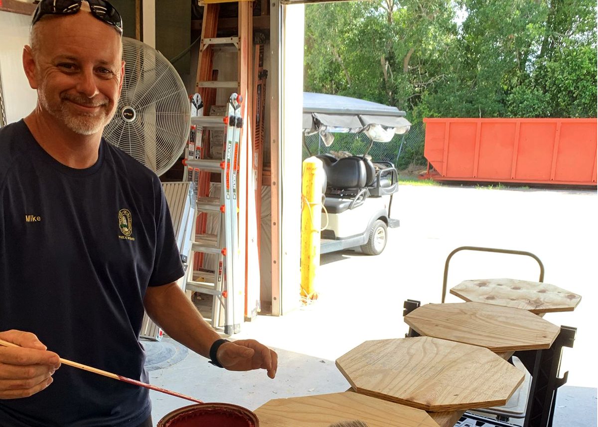 Mike Harris with Bald Head Island Public Services paints replacements for some of at least 16 estimated stop signs vandalized in the village in this July 2021 Department of Public Safety photo. The hijinks have continued in the summers since.