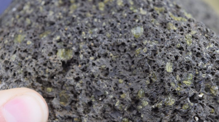 Olivine cystals are visible in this piece of lava rock, the source of Papakolea Beach's green sand. Photo: Tomintx/Creative Commons