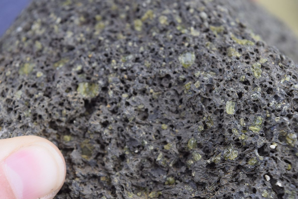 Olivine cystals are visible in this piece of lava rock, the source of Papakolea Beach's green sand. Photo: Tomintx/Creative Commons