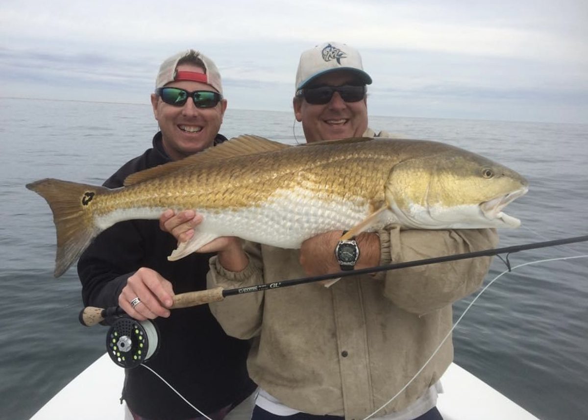 Chris Ellis, left, of Mississippi caught this monster red on a fly off Cape Lookout with Capt. Gordon.