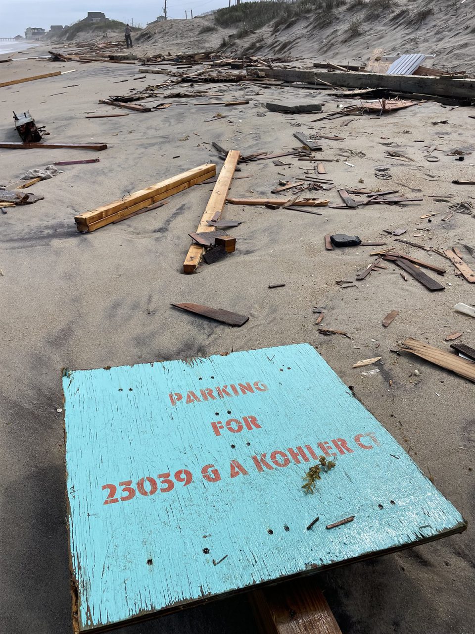 A sign denoting a parking area for the house formerly at 23039 G A Kohler Court lies among the debris scattered for miles along the beach. Photo: National Park Service