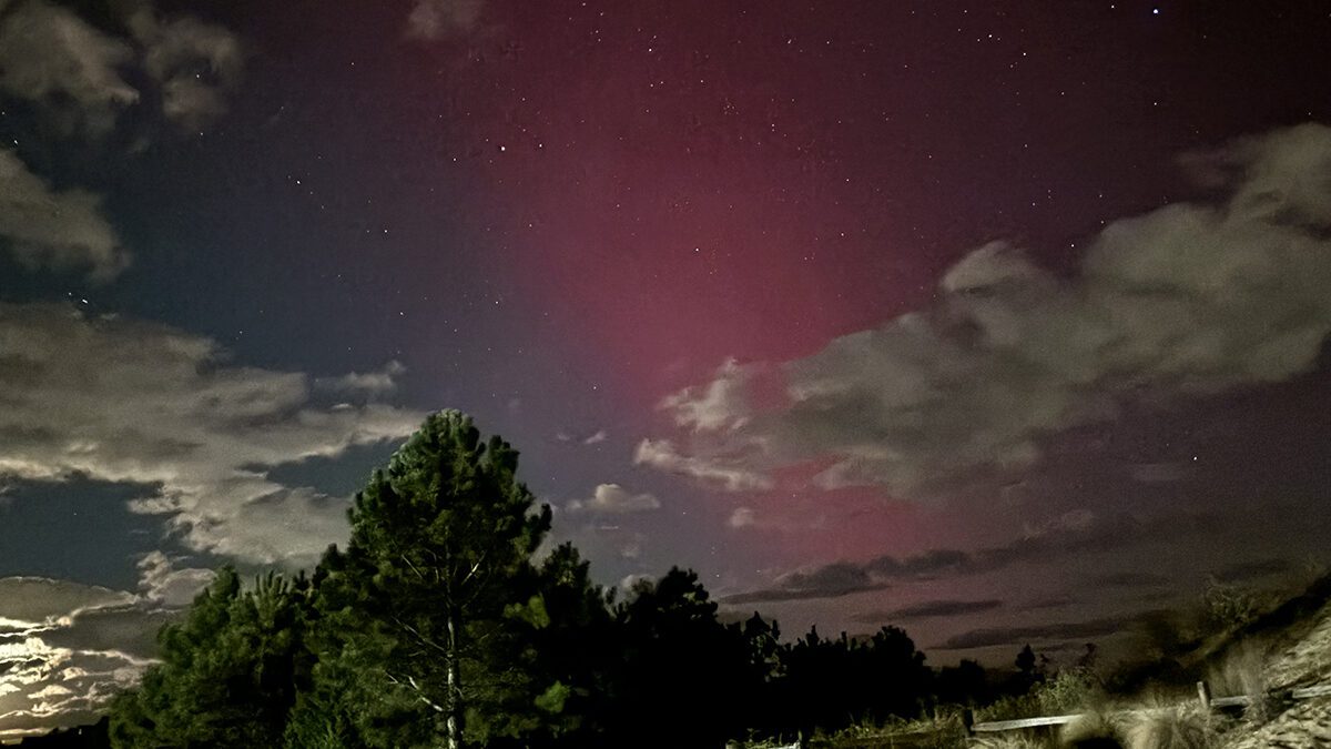 Aurora borealis, the result of an intense solar geomagnetic storm reaching Earth, lights up the skies over Jockey's Ridge State Park late Thursday evening. Photo: Catherine Kozak