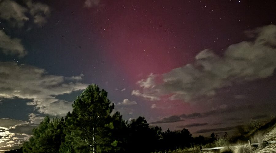 Aurora borealis, the result of an intense solar geomagnetic storm reaching Earth, lights up the skies over Jockey's Ridge State Park late Thursday evening. Photo: Catherine Kozak