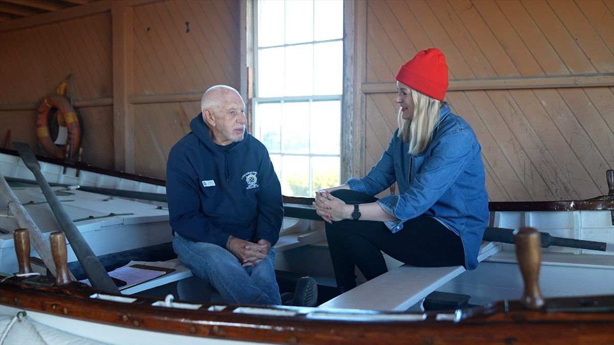 Chicamacomico Historic Site Executive Director John Griffin is interviewed by PBS director and producer, Rebecca Ward in Surfboat No. 1046, which was used in the Mirlo rescue. Photo: PBS-NC