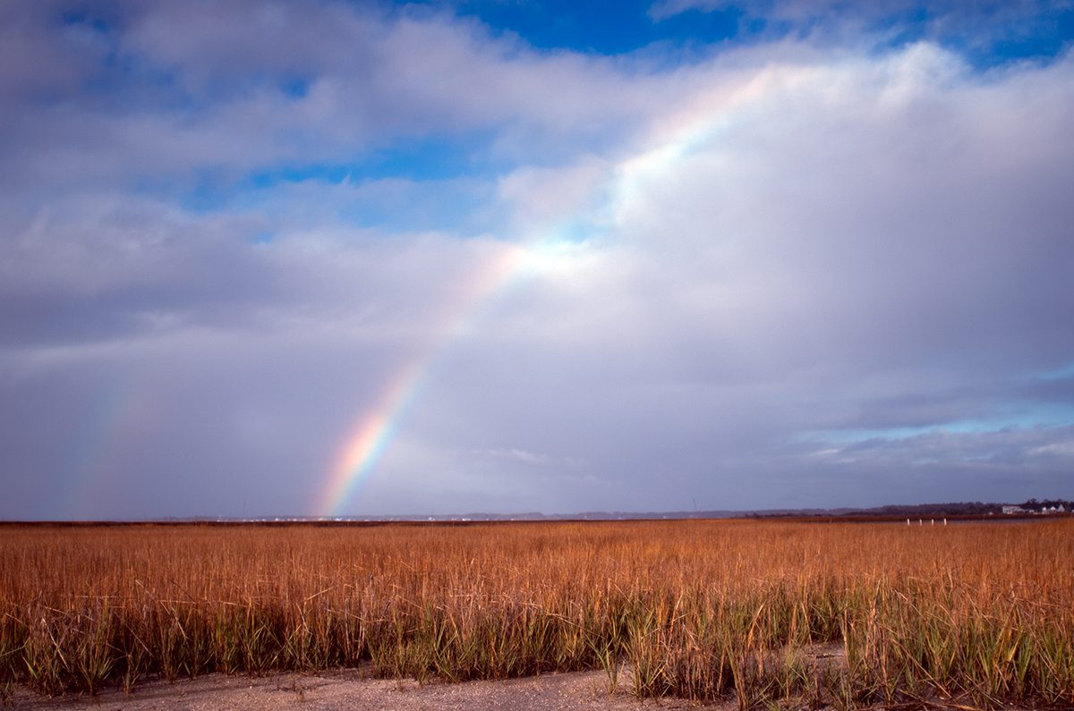 A rainbow reaches skyward from the Newport River as viewed from the marsh at Radio Island following Sunday showers. The island was formed by the placement of dredge spoils from an early channel deepening project at the Morehead City port in the 1930s and takes its name from Carteret Broadcasting Co.'s WMBL, which began broadcasting in 1947 at 740 kHz. Photo: Mark Hibbs