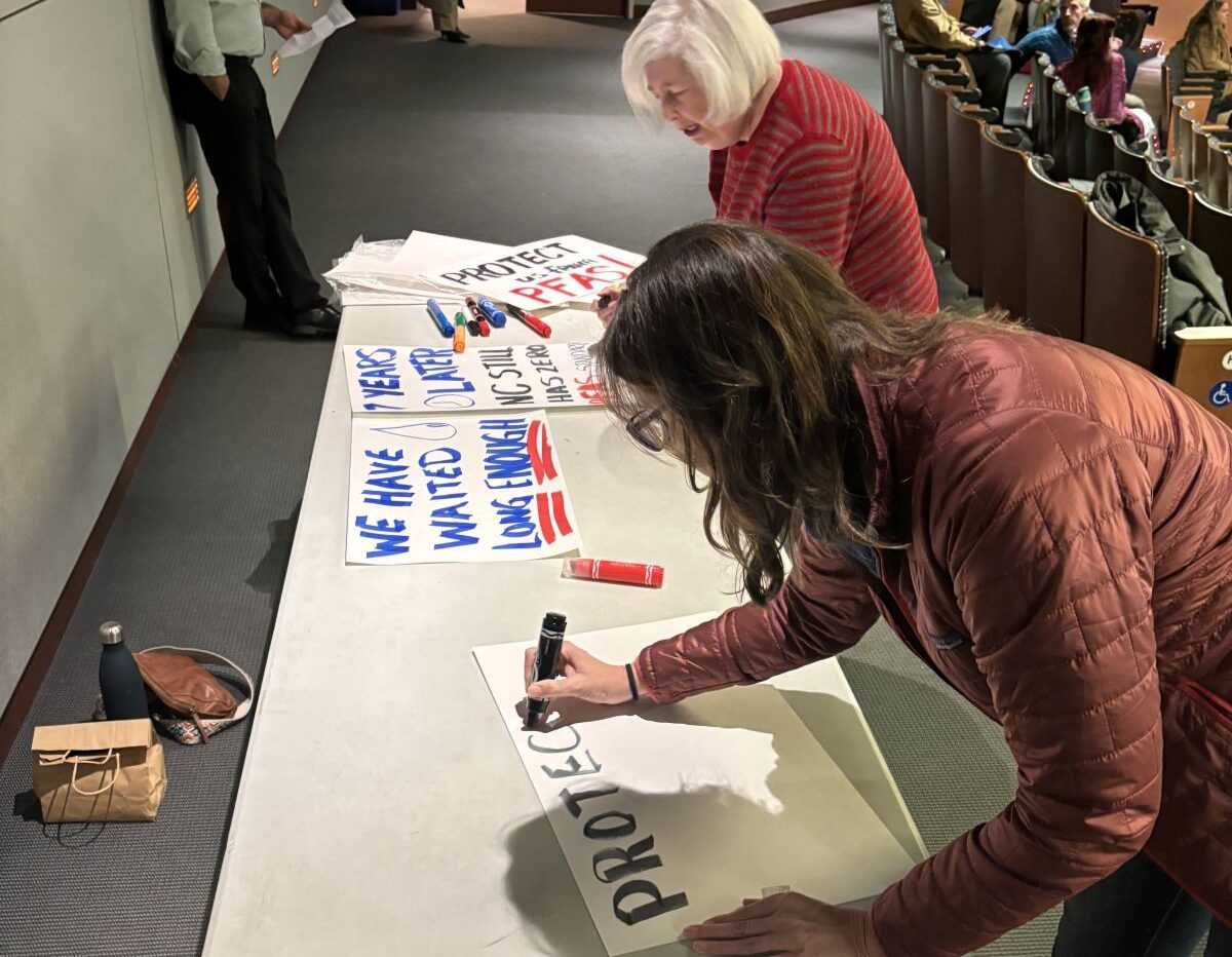 Clean Cape Fear Co-Founder Emily Donovan, front, is joined by fellow Brunswick County resident Joanne Levitan on Monday night in Wilmington at a public hearing on a proposed draft rule that would set health standards for three PFAS in groundwater. Roughly 50 residents attended the hearing. Photo: Trista Talton