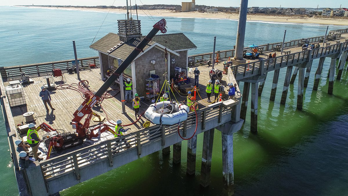 A wave energy converter is lowered over the side of Jennette’s pier in Nags Head. The device was tested in conjunction with the U.S. Department of Energy’s National Renewable Energy Laboratory and is designed to harness the power of waves to generate energy, and/or desalinate water. Photo: ECU