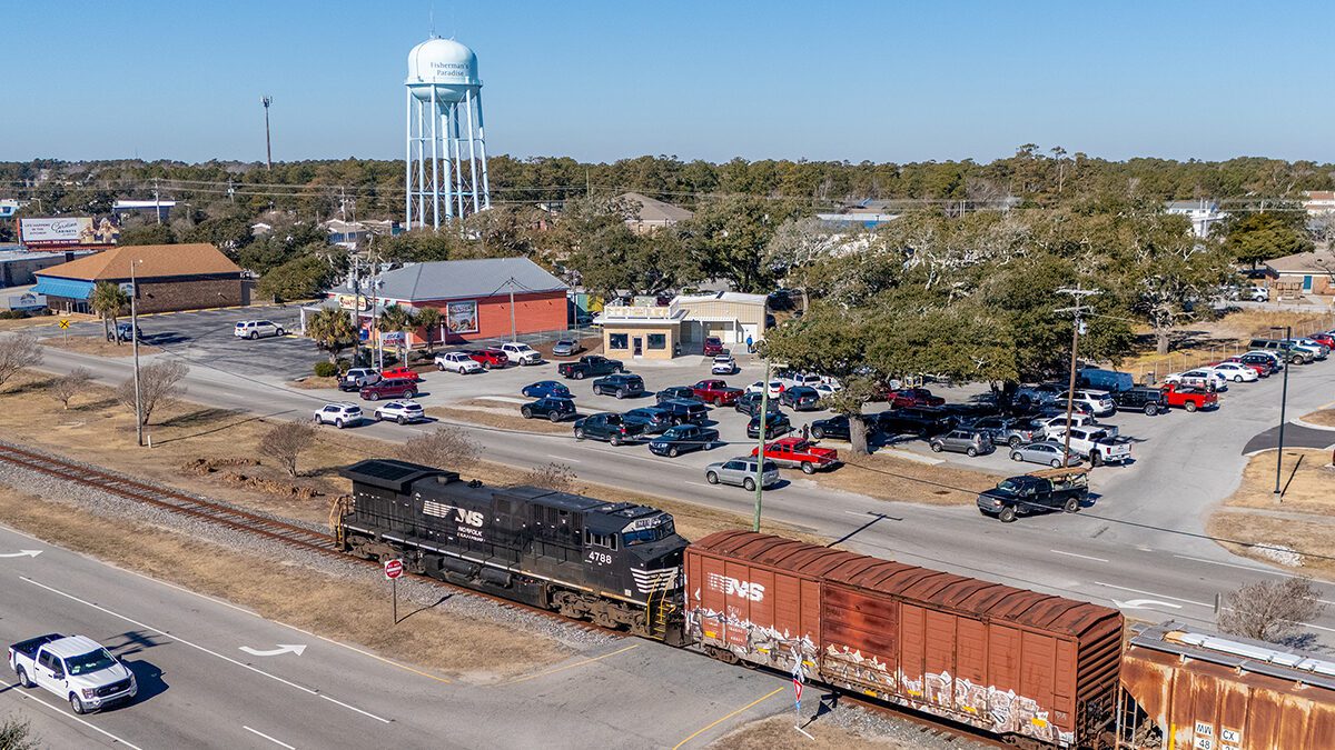 A Norfolk-Southern locomotive passes by the first-come-first-serve parking lot at El"s Drive-In, which recently reopened after rebuilding its original brick box on Arendell Street in Morehead City, long a popular stop for those on their way to or returning home from the beach. Photo: Dylan Ray