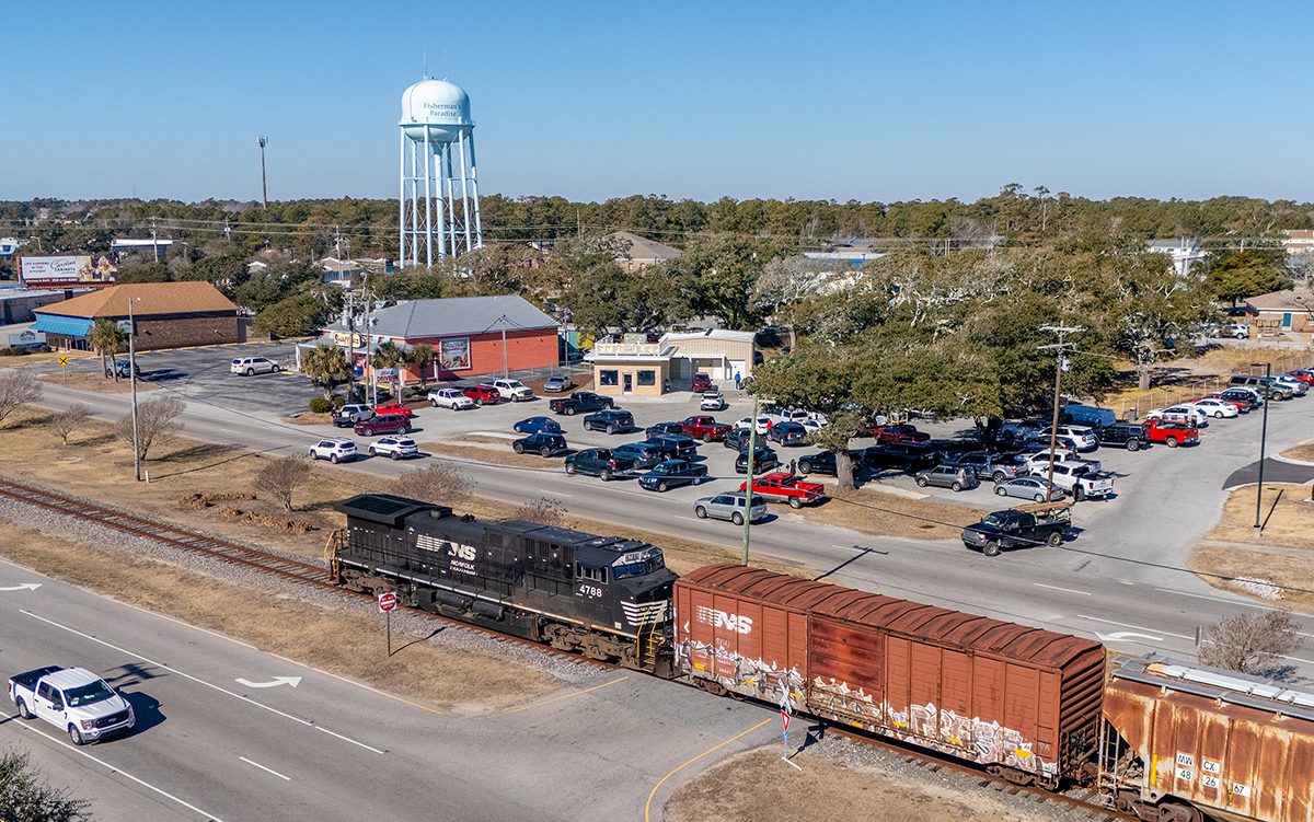 A Norfolk-Southern locomotive passes by the first-come-first-serve parking lot at El"s Drive-In, which recently reopened after rebuilding its original brick box on Arendell Street in Morehead City, long a popular stop for those on their way to or returning home from the beach. Photo: Dylan Ray