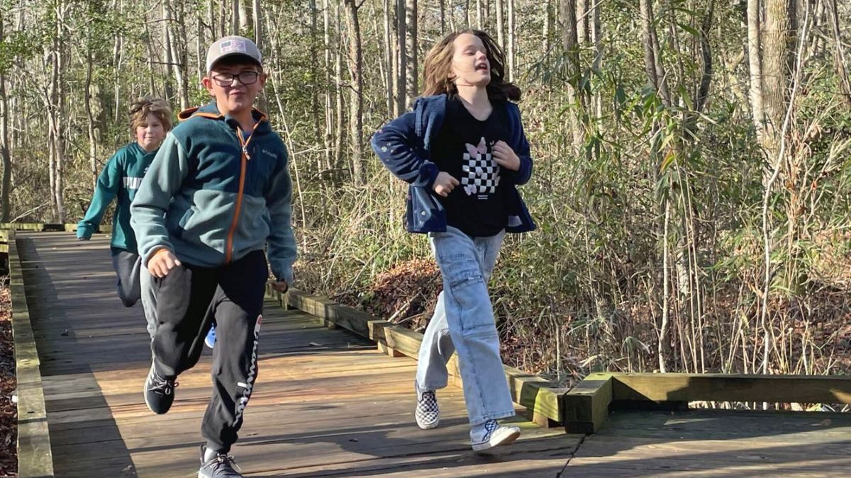 Eli Stratton, 8, left, Emilia Clipston, 8, right, and Grayson Morris, 8, rear, pick up the pace along a boardwalk at Dismal Swamp State Park during the First Day Hike at the state park in South Mills on Wednesday. The First Day Hike is an annual event at the park held on Jan. 1. Photo: Kesha Williams/ The Daily Advance