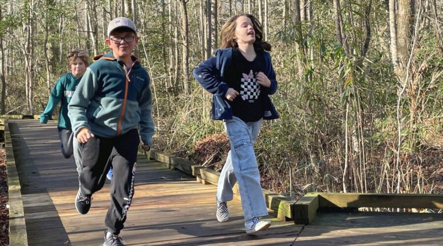 Eli Stratton, 8, left, Emilia Clipston, 8, right, and Grayson Morris, 8, rear, pick up the pace along a boardwalk at Dismal Swamp State Park during the First Day Hike at the state park in South Mills on Wednesday. The First Day Hike is an annual event at the park held on Jan. 1. Photo: Kesha Williams/ The Daily Advance