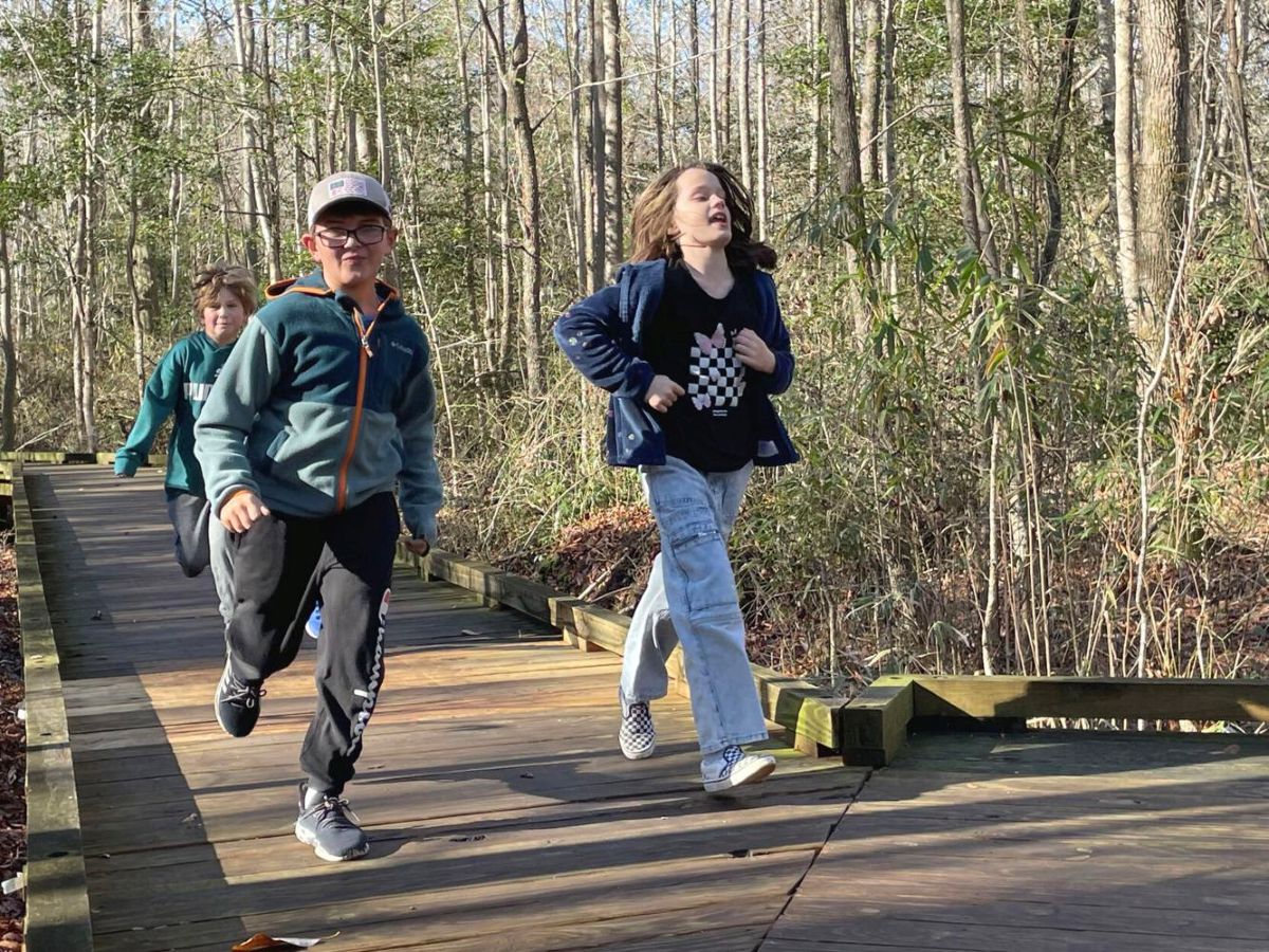 Eli Stratton, 8, left, Emilia Clipston, 8, right, and Grayson Morris, 8, rear, pick up the pace along a boardwalk at Dismal Swamp State Park during the First Day Hike at the state park in South Mills on Wednesday. The First Day Hike is an annual event at the park held on Jan. 1. Photo: Kesha Williams/ The Daily Advance