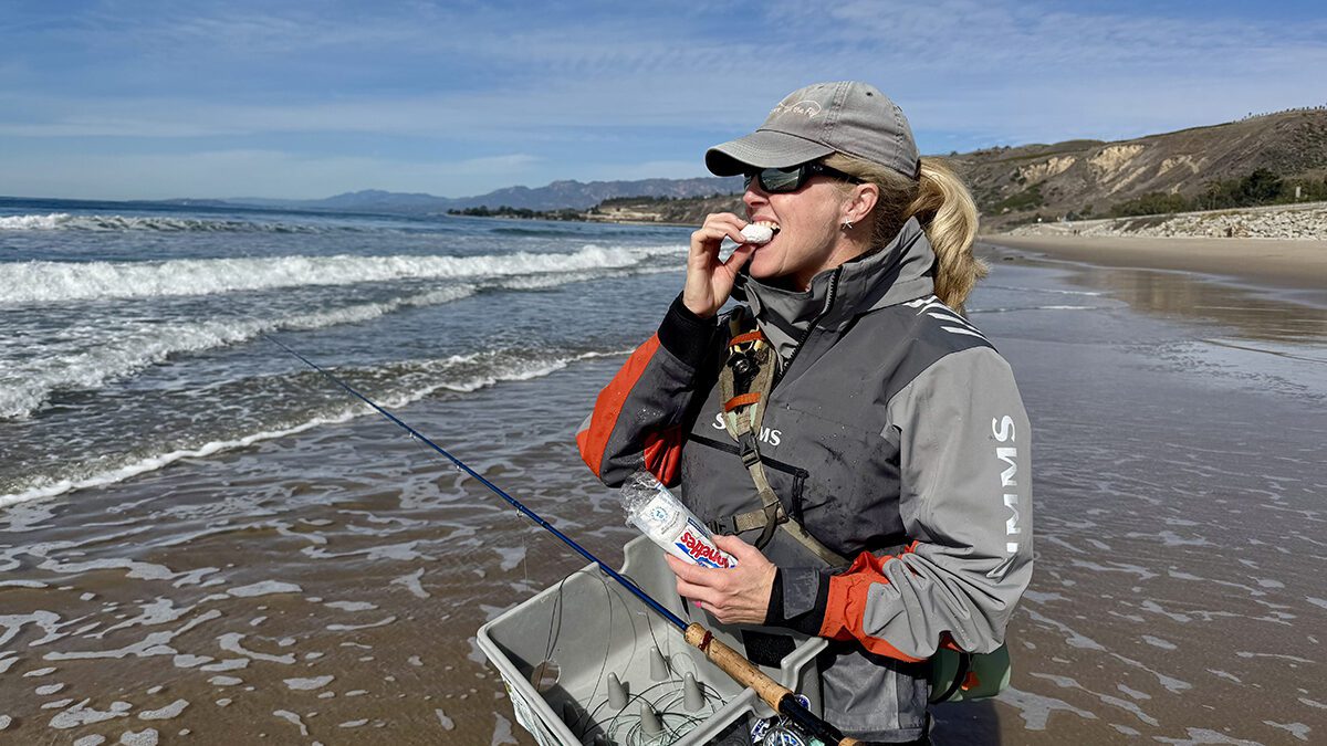 Kesley Gallagher enjoys a powdered donut while fly fishing the surf of Santa Barbara, California. Photo: Gordon Churchill