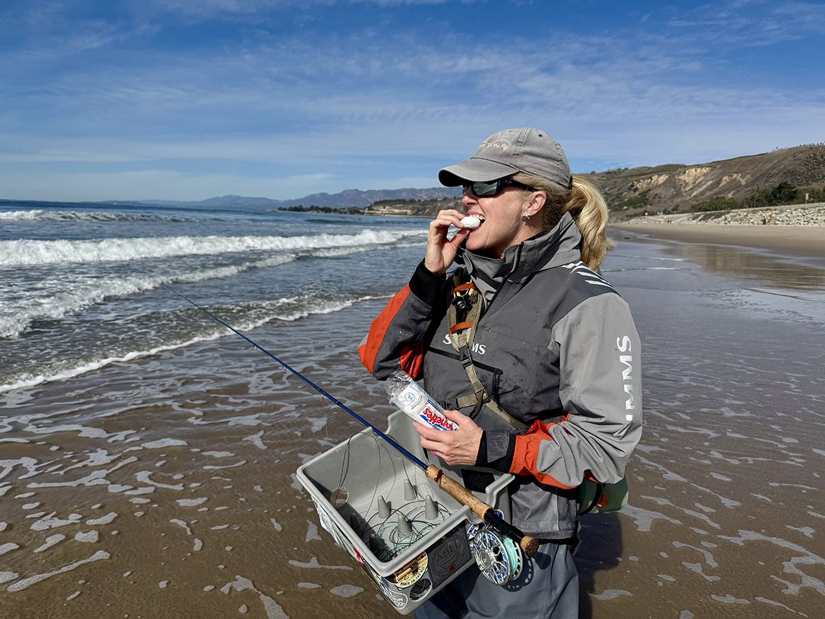 Kesley Gallagher enjoys a powdered donut while fly fishing the surf of Santa Barbara, California. Photo: Gordon Churchill