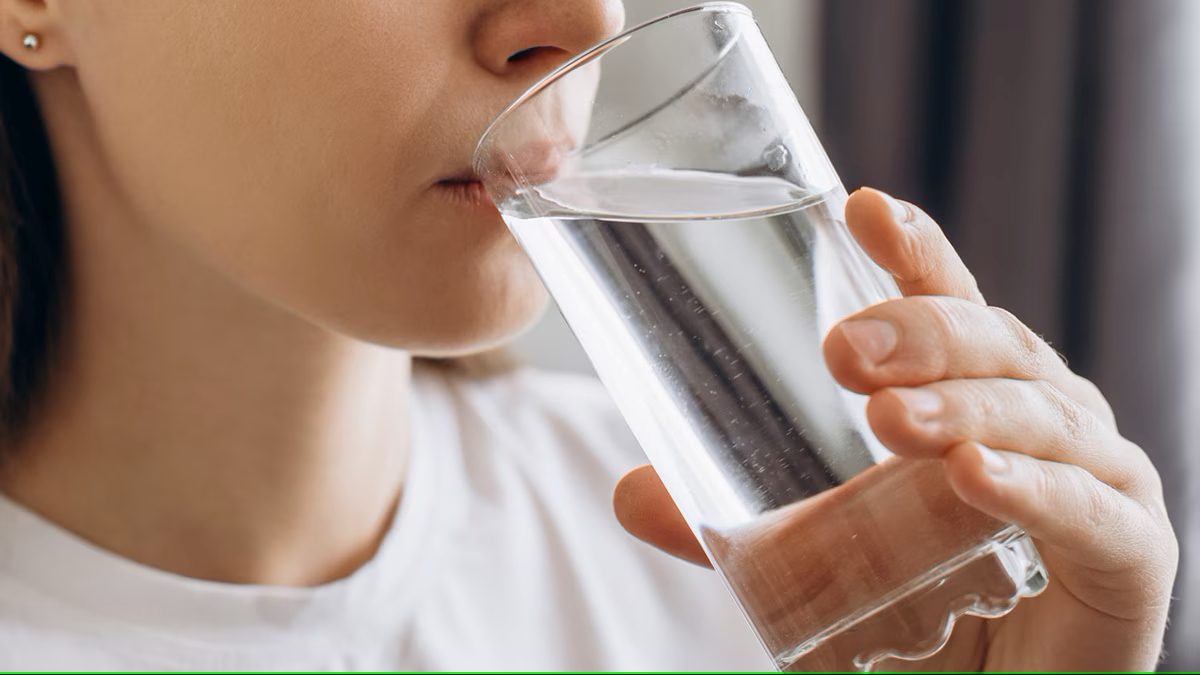 A woman holds a glass of water. Photo: CDC