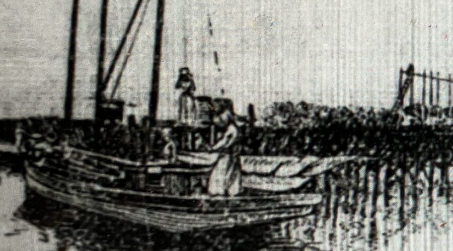 The naphtha launch Violet coming into the Straits east of Beaufort, in the Down East part of Carteret County, N.C. In the distance, we can see a windmill and a menhaden factory on Harkers Island. (Raleigh News & Observer, 13 May 1903)