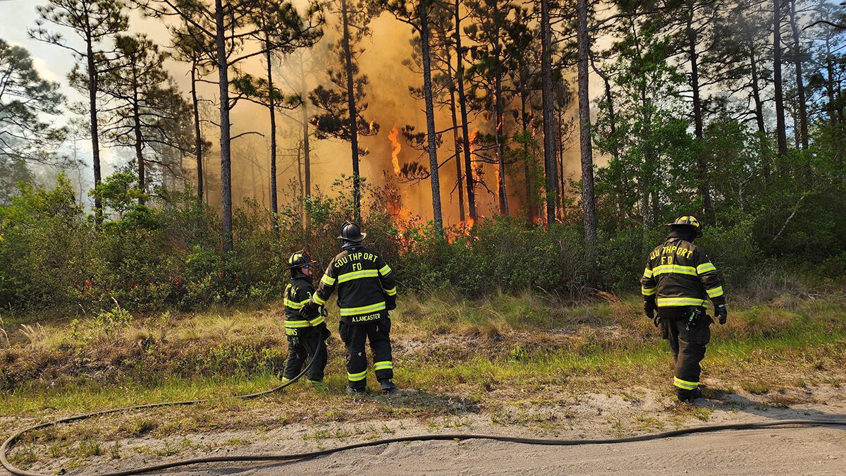 A Southport Fire Department crew is shown working at the 1,500-acre wildfire in Brunswick County in this image Boiling Spring Lakes Fire Rescue posted Friday on social media.