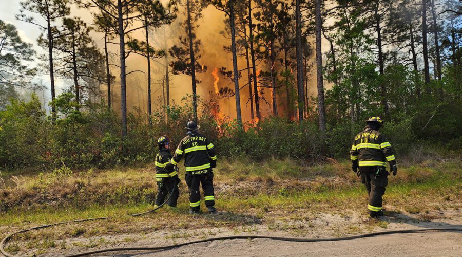 A Southport Fire Department crew is shown working at the 1,500-acre wildfire in Brunswick County in this image Boiling Spring Lakes Fire Rescue posted Friday on social media.