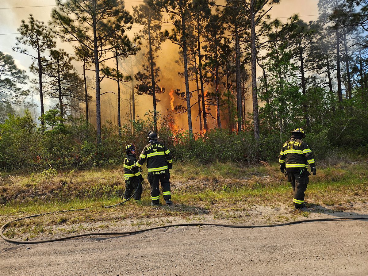 A Southport Fire Department crew is shown working at the 1,500-acre wildfire in Brunswick County in this image Boiling Spring Lakes Fire Rescue posted Friday on social media.