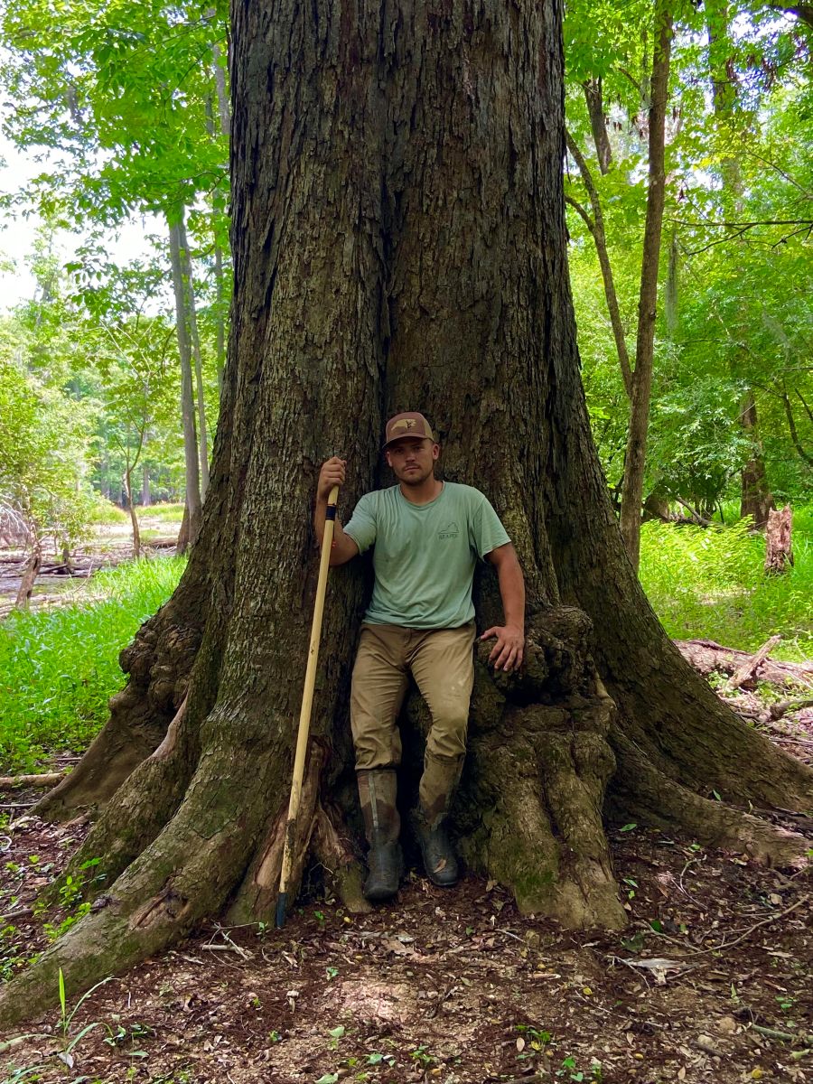 Luke Ferreira, a big-tree hunter originally from New Bern, stands with champion water hickory. Photo: courtesy, Ferreira