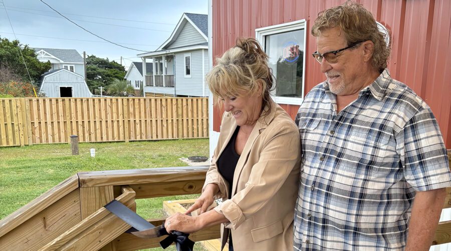 Jeffrey Aiken, right, stands with Mary Ellon Ballance, as she uses a fileting knife during the ribbon-cutting celebration May 21 for Jeffrey's Seafood's official opening. Photo: Lynne Foster