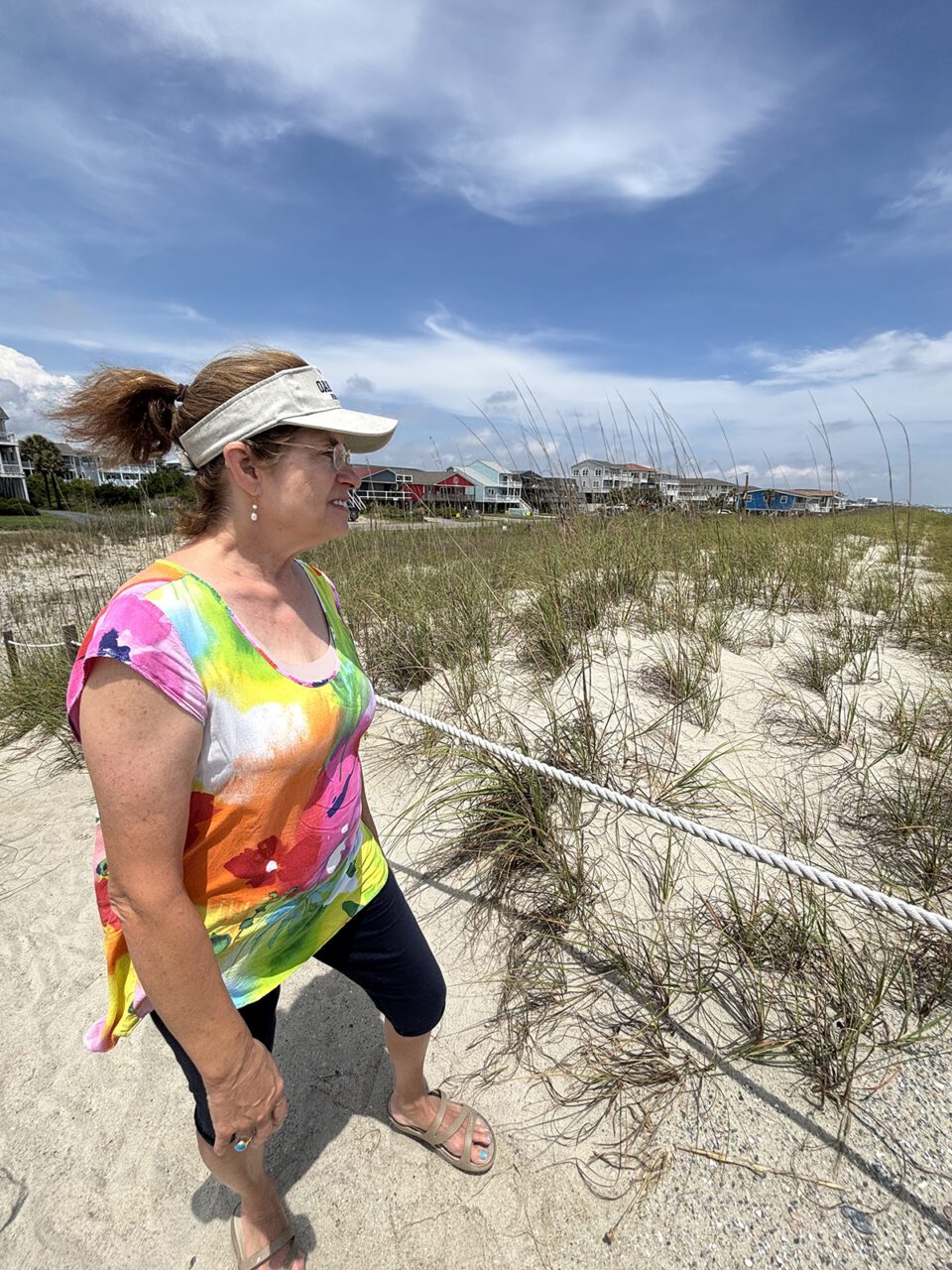 Gigi Donovan looks out May 29 over the man-made dune across from her Oak Island home. Photo: Trista Talton